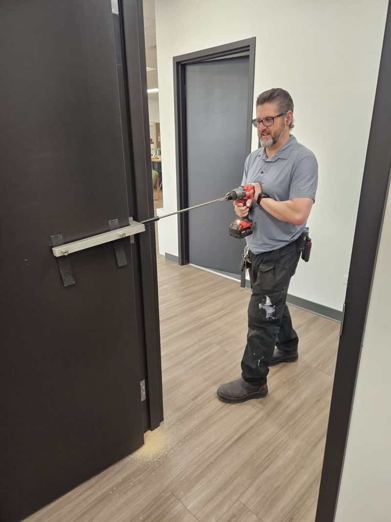 Scott Duboff drilling a commercial door to install hardware